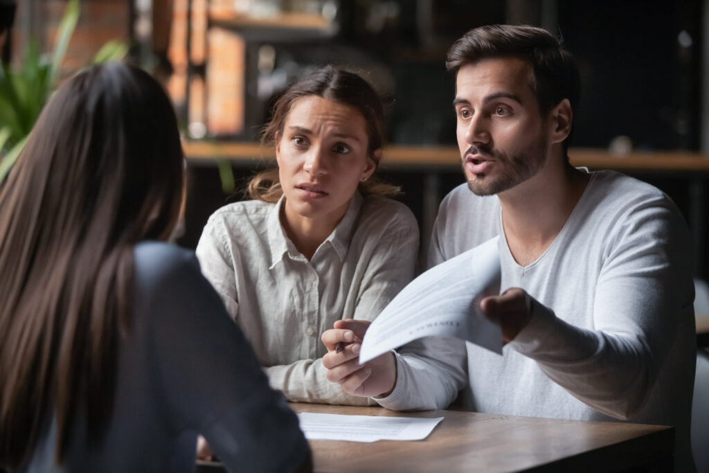 Angry couple arguing with insurance manager about bad faith insurance practice